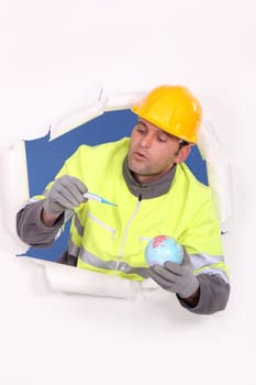 Builder holding globe and pregnancy test