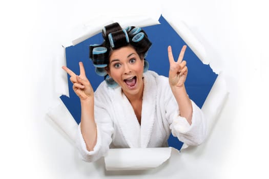 Crazy girl gesturing with bathrobe and hair curlers