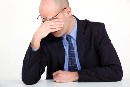 tired businessman rubbing his eyes