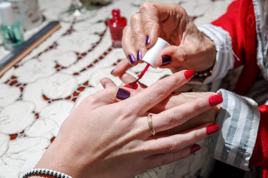 Hands of young woman by becoming Manicure