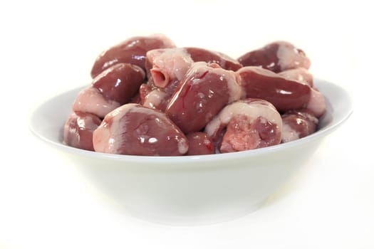 fresh raw chicken hearts against a white background