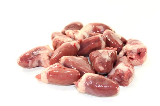 fresh raw chicken hearts against a white background