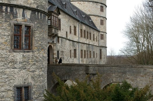 Büren,Germany – March 01,2014: Two people cross a bridge into the Wewelsburg on March 1,2014 in Büren.