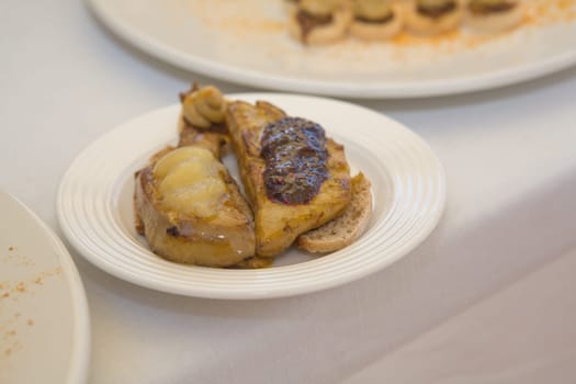 Placing the hot grilled foie gras over bread slices