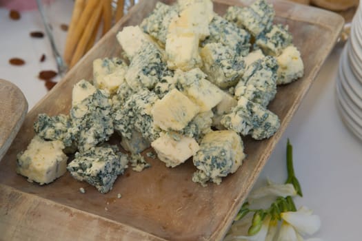 Cubes of delicious blue cheese on a wooden tray, Spain