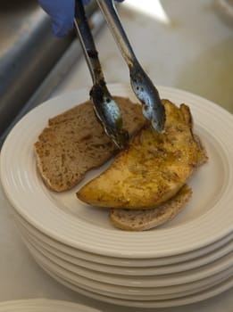 Placing the hot grilled foie gras over bread slices