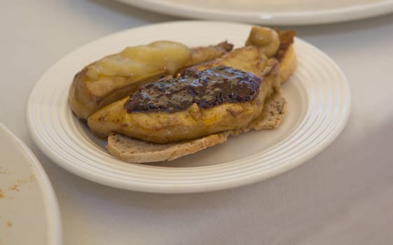 Hot grilled foie gras over bread slices with apple and strawberries jam on the top