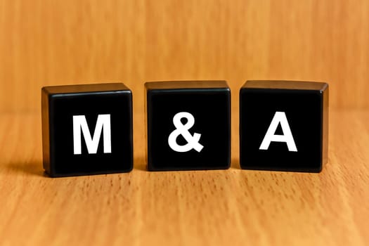 M&A or Merger and Acquisition text on black block