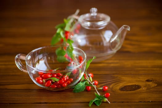 Branch with ripe red goji berry on a brown wooden table