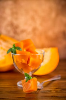 Prepared sweet pumpkin marmalade in a glass bowl on a wooden table. Autumn recipes.