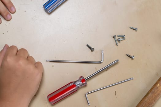 the ironing iron is broken. the master repairs the iron in the workshop on the table using tools. Disassembled electric iron.