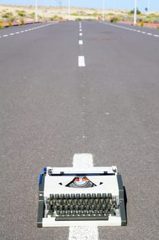 On the Road Writing Concept Typewriter over an Asphalt Street