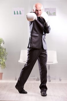 fighting business man upright and ready with white gloves