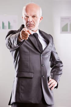 businessman pointing at you with an extremely serious expression