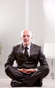 relaxed businessman meditating with the leg crossed