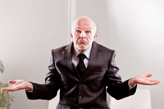 feeble businessman expressing impotence with a typical italian gesture