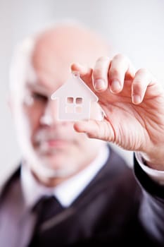 Man looking through a little transparent house in his hand