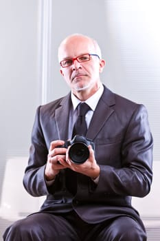 elegant man looking at camera with a DSLR camera in his hands