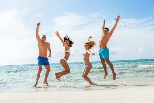 group of laughing young people on the beach in summer holiday leisure lifestyle