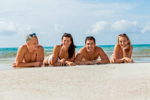 group of laughing young people on the beach in summer holiday leisure lifestyle