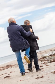 older adult happy couple walks on the beach in autumn lifestyle happiness