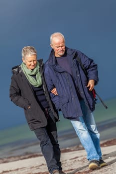 older adult happy couple walks on the beach in autumn lifestyle happiness