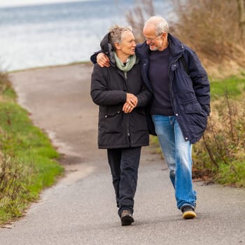 older happy couple makes a beach walk in autumn baltic sea landscape sea