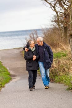 older happy couple makes a beach walk in autumn baltic sea landscape sea