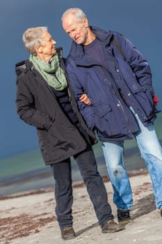 older adult happy couple walks on the beach in autumn lifestyle happiness