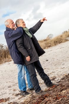 older adult happy couple walks on the beach in autumn lifestyle happiness