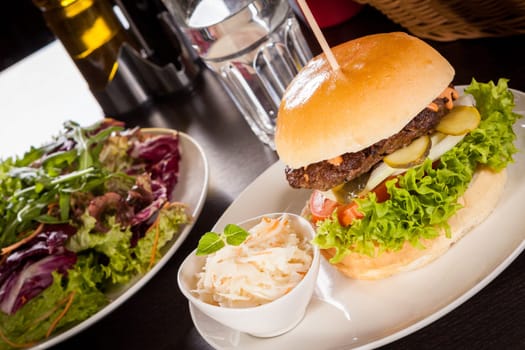 Delicious hamburger cheeseburger with bacon egg and salad on a plate
