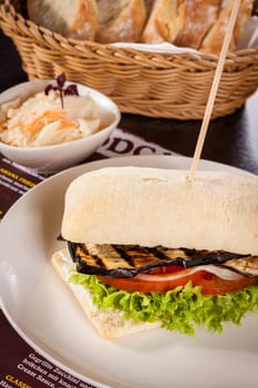 Vegetarian vegan hamburger with aubergine tomato and salad in a ciabatta bun