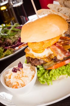 Delicious hamburger cheeseburger with bacon egg and salad on a plate