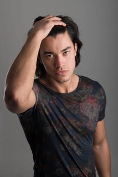 Portrait of handsome Malaysian man wearing flowery top with hands on hair