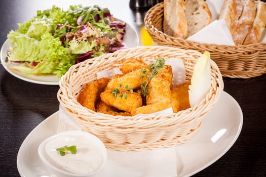 Fresh chicken flails and nuggets golden fried in a basket