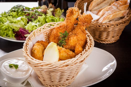 Crispy fried chicken wings with a dip on a plate