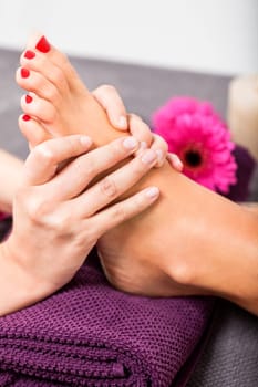 Woman with pedicure in a beauty salon on a towel with lactated toe nails