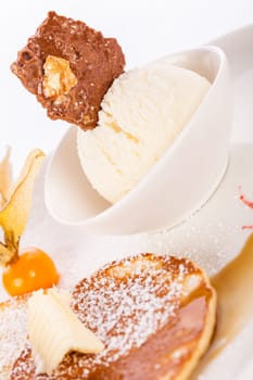 Delicious sweet pancakes as desser with vanilla ice cream prepared on a white plate insulated against a white background