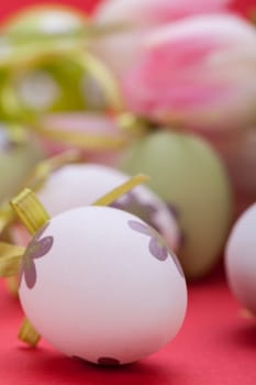 pink tulips decorated with easter eggs as a close-up with text space on a red background