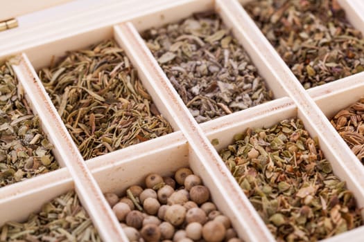 various dried herbs spices in a wooden box macro detail aufnahme