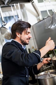 young adult chekoch in the restaurant kitchen at the herd while cooking