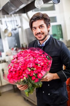 young chef with red roses in the hand table decoration romantik dinner restaurant