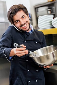 young chef on the phone while cooking in the restaurant kitchen work success stress communication