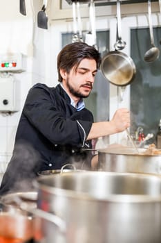 young adult chekoch in the restaurant kitchen at the herd while cooking
