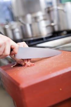 chef cuts fresh red meat in the restaurant kitchen gastronomy food work cooking