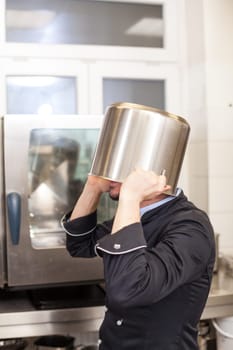 young adult chef in the restaurant kitchen while cooking at the herd preparation