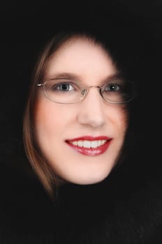 A closeup picture of a very pretty young woman in a black feather hood.with glasses on..