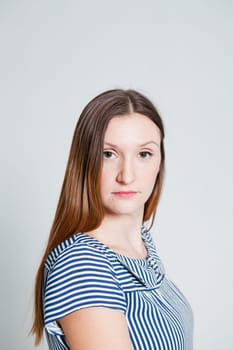 Studio portrait of serious looking attractive and stylish woman