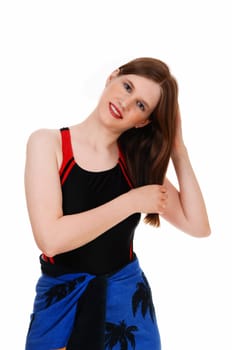 A lovely young woman in a black bathing suit standing from the front.fixing her hair for white background..