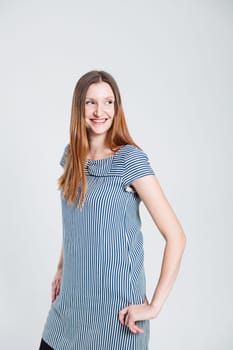 Studio portrait of smiling attractive and stylish woman posing while looking to side
